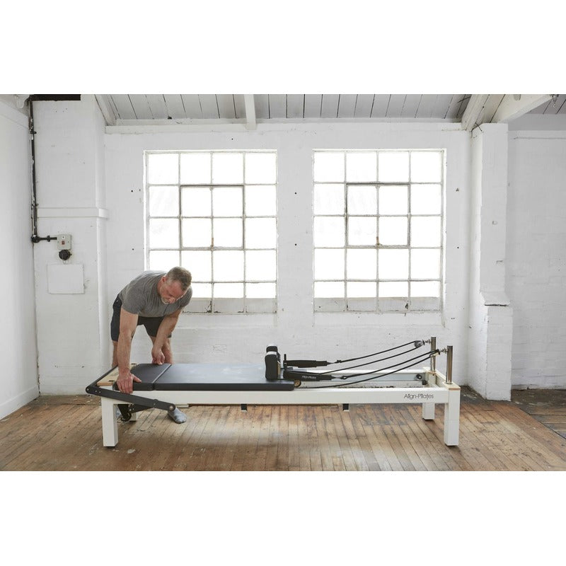 Align-Pilates C8-S Pro Pilates Reformer with man adjusting reformer